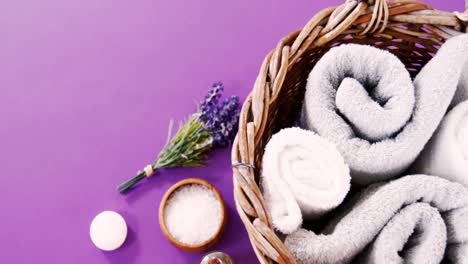 sea salt in wooden bowl, towel, oil, candle and flowers