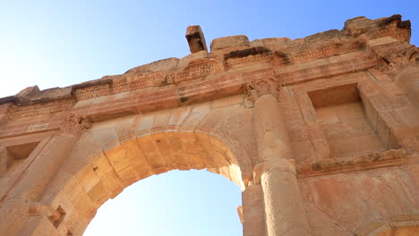 Sunset-light-bathing-the-arch-of-the-ancient-Sbeitla-Roman-ruins-in-Tunisia,-clear-sky