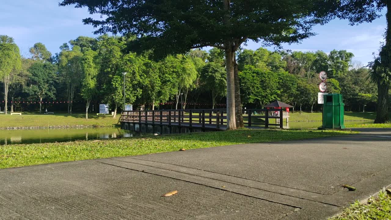 A wooden bridge gracefully spans a tranquil lake, designed exclusively for pedestrian use. This scenic walkway offers serene views of the surrounding waters.