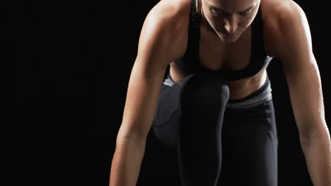 Focused-young-Caucasian-woman-athlete-engages-in-an-intense-workout-on-a-black-background,-with-copy