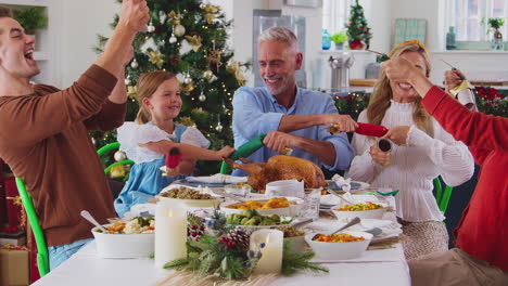 Familie-Mit-Mehreren-Generationen-Feiert-Weihnachten-Zu-Hause-Und-Zieht-Cracker,-Bevor-Sie-Gemeinsam-Essen