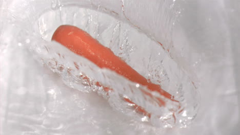 la zanahoria cayendo en el agua en cámara súper lenta