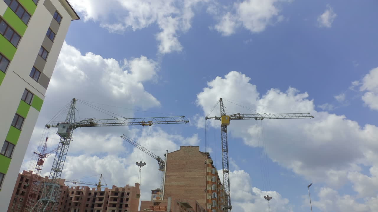 Grúas de construcción sobre casas. Timelapse. Construcción de edificios residenciales