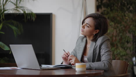 arabian hispanic woman working financial paperwork seated at workplace using laptop looks concentrated while makes task prepare check report having fruitful workday. student learning process concept