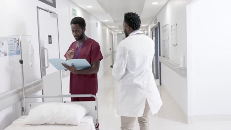 focused diverse male doctors talking and female nurse with wheelchair in slow motion, unaltered