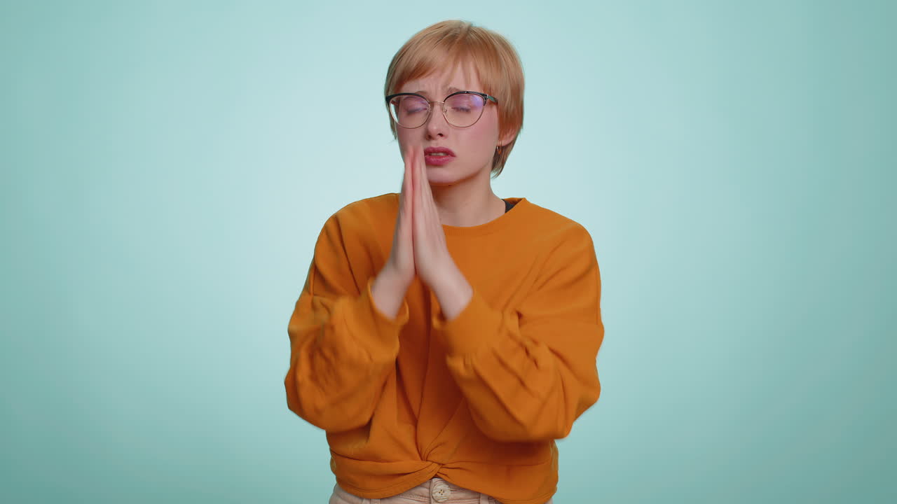 Attractive woman praying looking upward making wish begging apology asking help forgive me