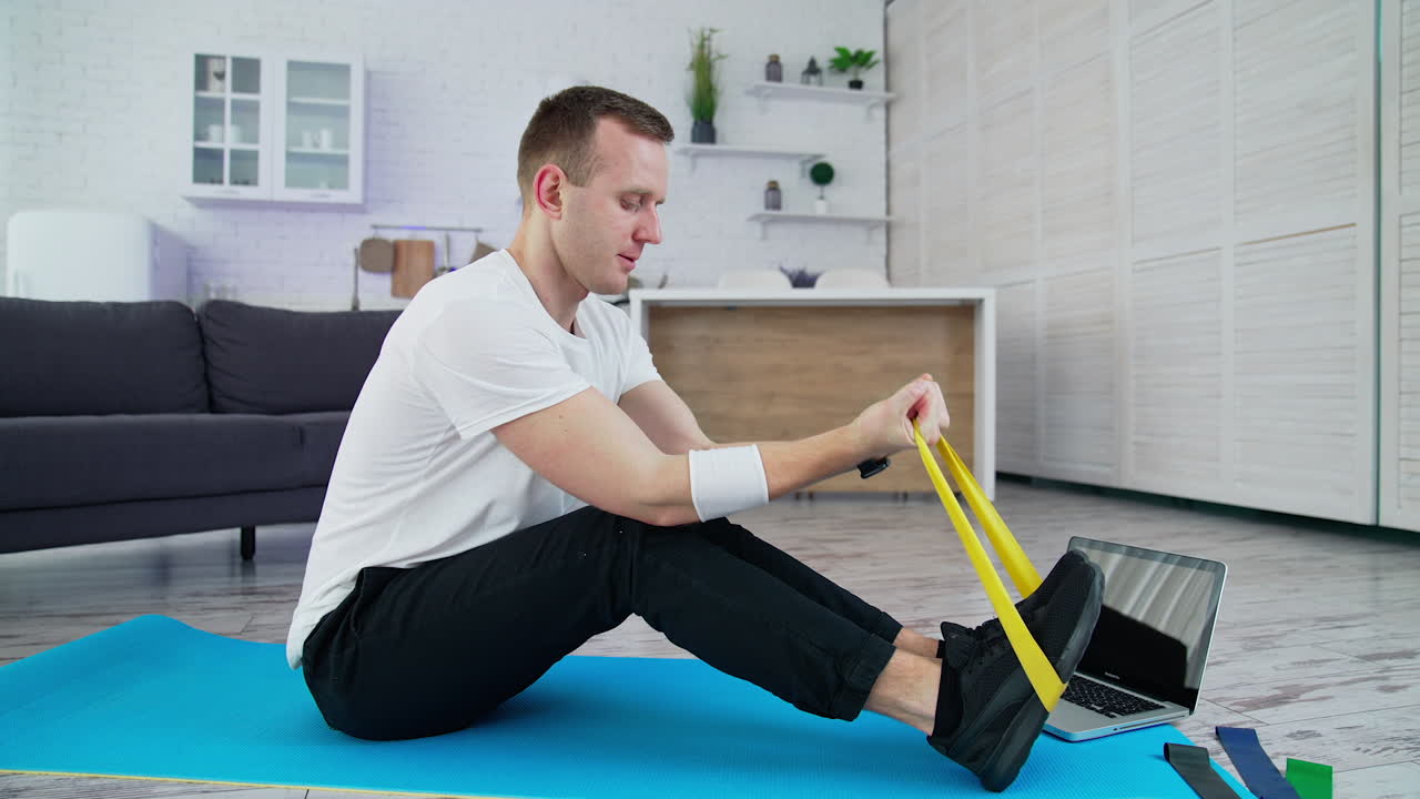 Handsome athletic man doing exercise in home. Indoor training on quarantine.