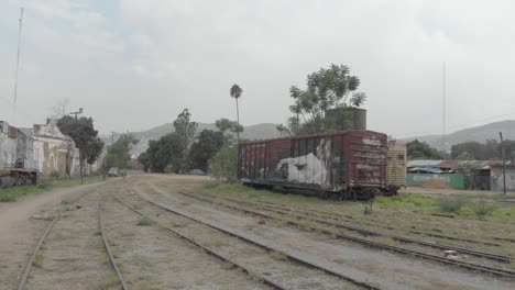 Tiro-Deslizante-Sobre-Viejas-Vías-A-Un-Vagón-De-Ferrocarril-Pintado-Con-Graffiti