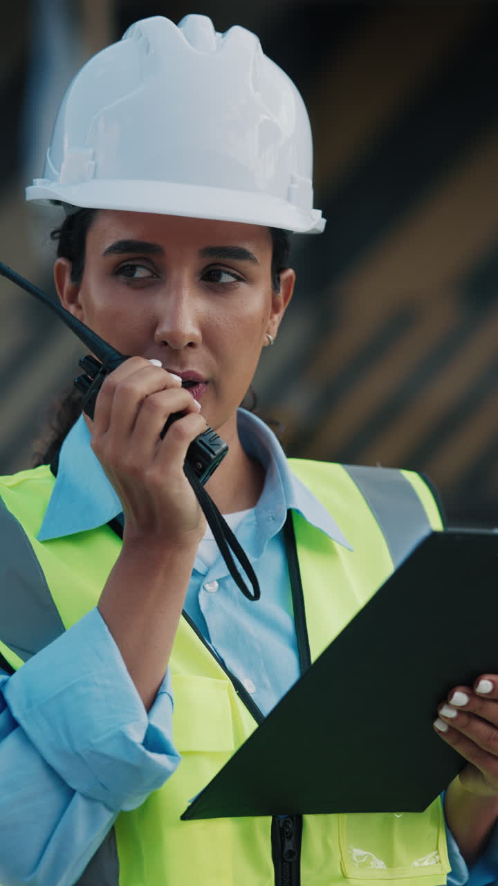 Construction worker using radio and clipboard