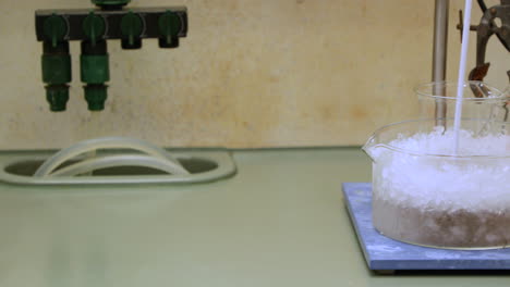 Stirring-Chemical-Solution-In-A-Beaker-Submerged-In-Ice-For-Cooling-In-Laboratory---slider-reveal