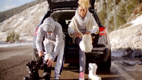 Couple-putting-on-skiing-boots