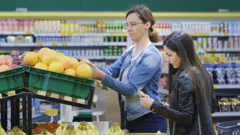women shopping for fruits at a grocery store