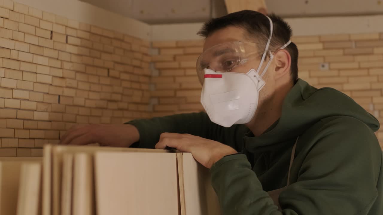 나무 가공자 가 플라이우드 판 을 점검 하고 있다