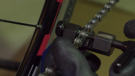 Closeup:-Link-pin-inserted-into-bike-chain-in-bicycle-shop-maintenance