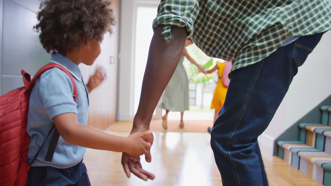 Parents At Home Helping Children Get Ready And Leave As Family Go To School Together