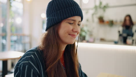 woman in beanie at cafe