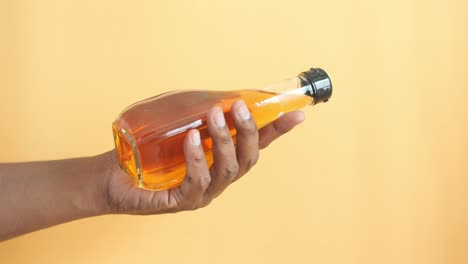 hand holding a bottle of vinegar