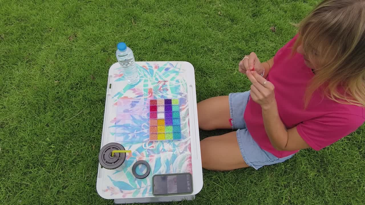 mujer con cuentas al aire libre en una mesa portátil