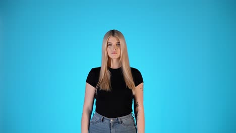 young blonde woman shrugging gesture, thinking and doubtful, colorful studio portrait