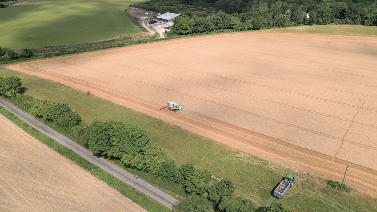 Farm Tractors Operating Over Fields During Harvest Season in Wilton, Marlborough, United Kingdom - Aerial Drone Shot