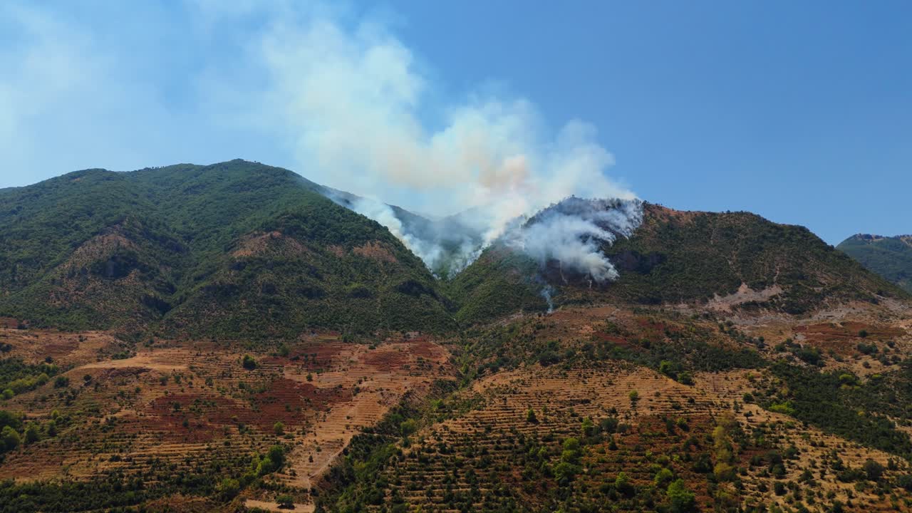 푸른 하늘 아래 알바니아 산맥에서 시작된 작은 불에서 연기가 아오른다.