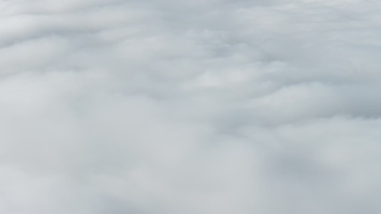 Aerial view of the snow-capped Churfirsten peaks soaring above a thick sea of fog (Nebelmeer) in Switzerland. High-altitude landscape conveying concepts of achievement, success