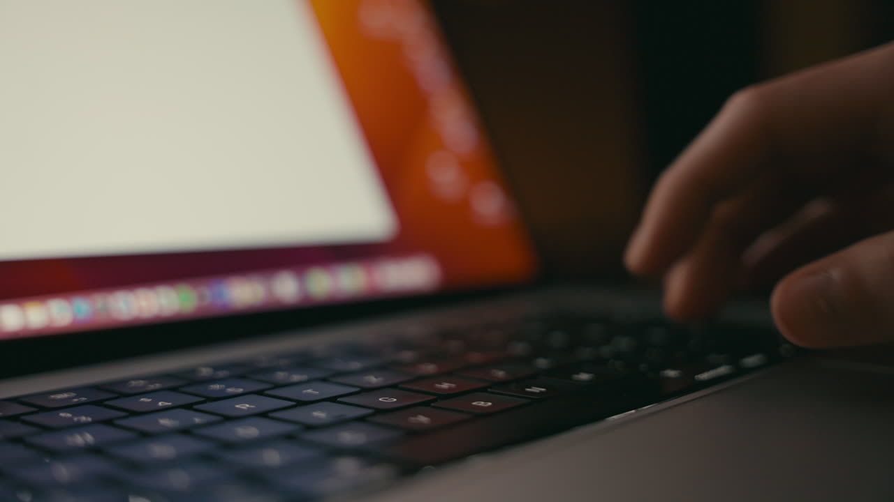 pessoa a digitar num portátil à noite