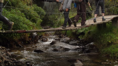 Old-Wooden-Bridge-with-Running-Water-Many-People-Walking-Across-Slow-Motion