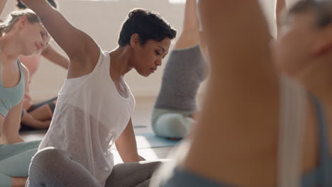 yoga class of beautiful women practice seated side bend pose enjoying healthy lifestyle exercising in fitness studio instructor teaching group meditation at sunrise