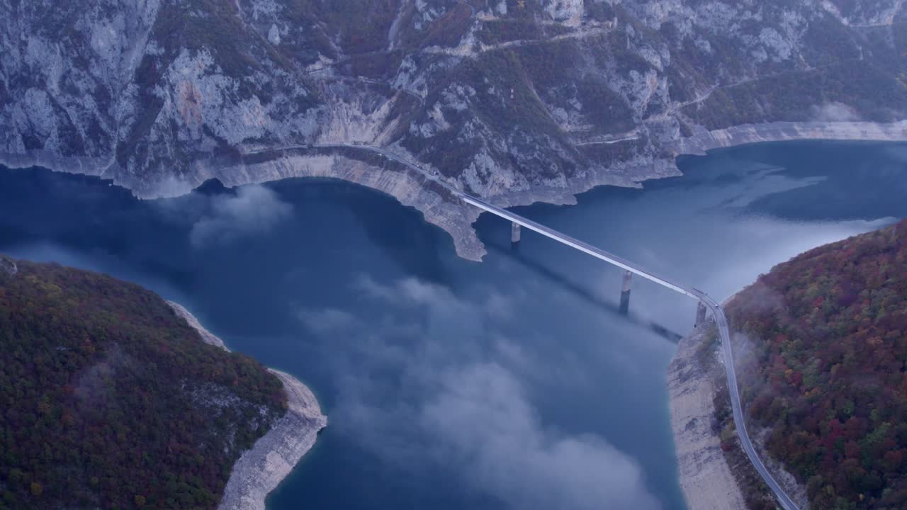 Montagne nebbiose circondano il Lago di Piva e il ponte, Plužine, Montenegro