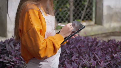 mujer usando tableta en el jardín