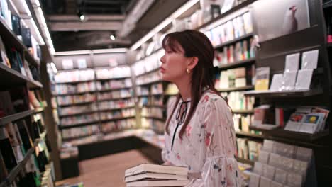 mujer revisando libros en una librería