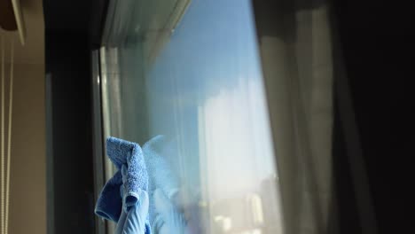 close up of a gloved hand cleaning a window