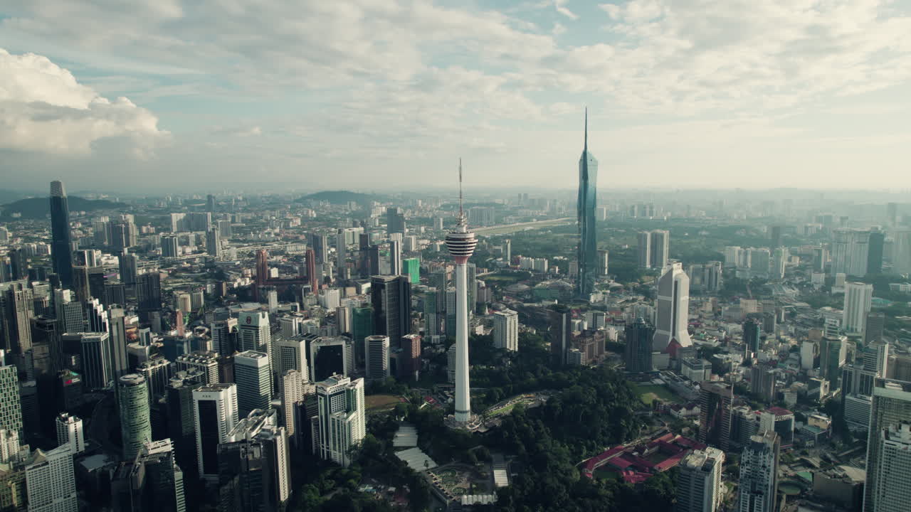 Wieża telekomunikacyjna w Kuala Lumpur z megawysokim drapaczem chmur Merdeka 118 po prawej, przed wschodem słońca, Azja Południowo-Wschodnia, panoramiczny widok z drona.