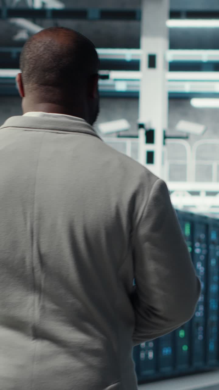 Vertical video Admin walking in data center, doing inspection on infrastructure tech