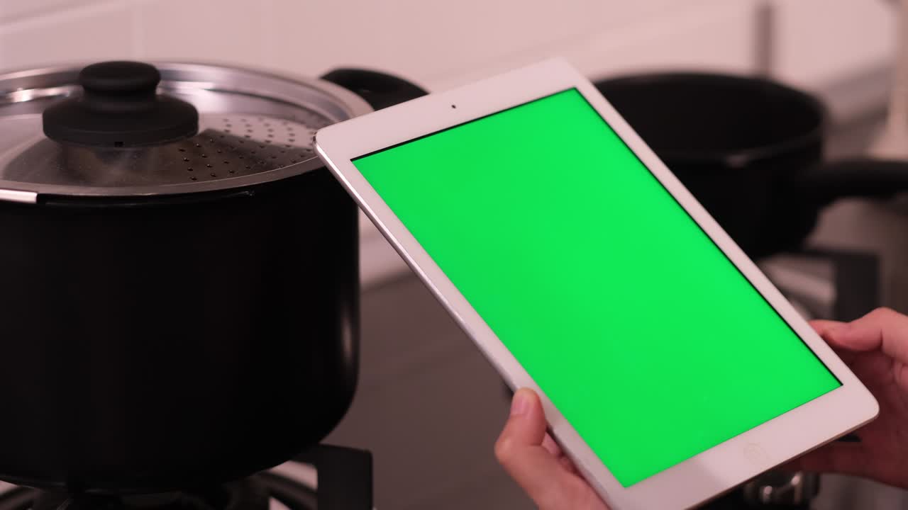 people using green screen tablet in kitchen.