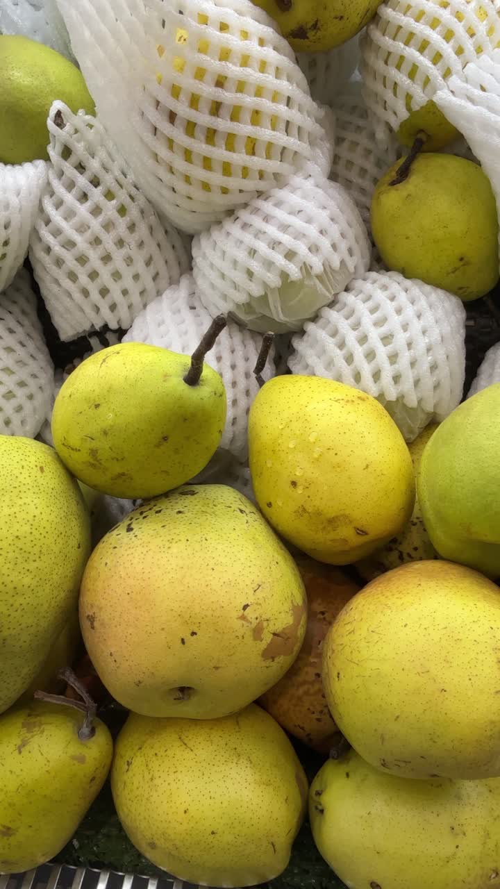 Primo piano di pere fresche gialle e verdi in un mercato