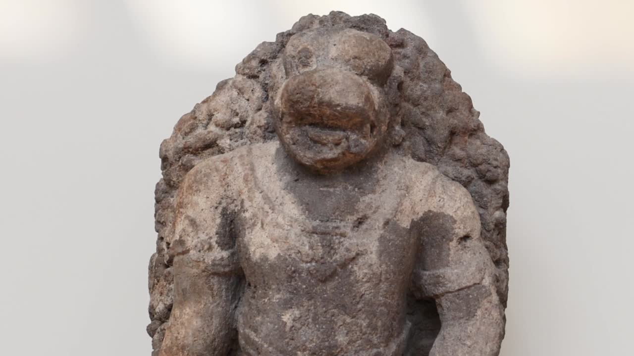 Close-up of a textured stone sculpture depicting an animal figure with intricate carving details.