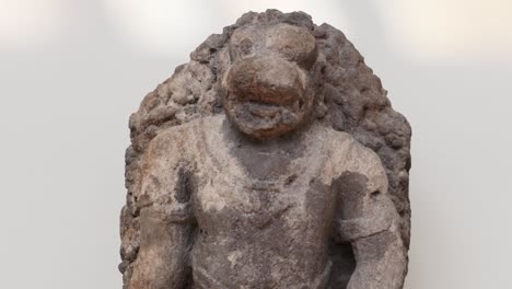 close-up of a textured stone sculpture depicting an animal figure with intricate carving details.