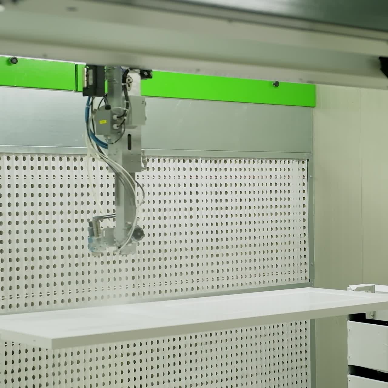 Industrial equipment for door production. Automated machine is painting wooden board in white color. Interior of modern manufacturing.