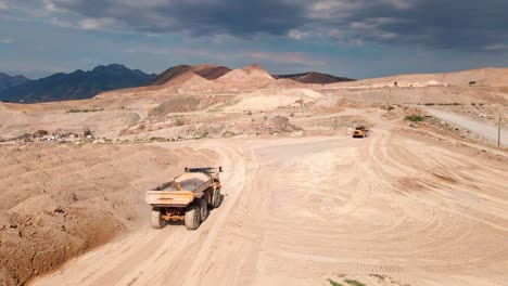 Dump-Trucks-Working-on-Gravel-Pit-Terrain-at-Bluffdale-Utah---Aerial-Close-Up