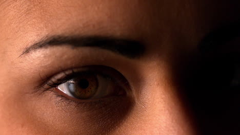 brunette woman blinking on black background