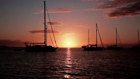 Sailing-yacht-silhouettes-at-sunset-in-an-anchorage