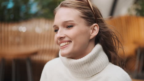 Mujer-Caucásica-Sonriendo-En-Un-Acogedor-Suéter-Al-Aire-Libre.