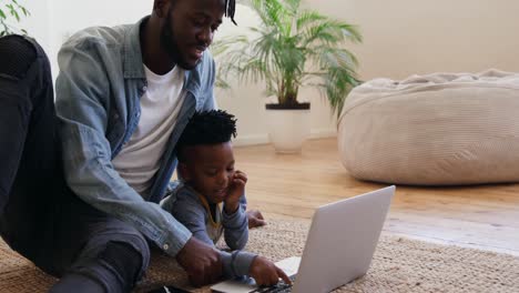 father and son using technology together at home