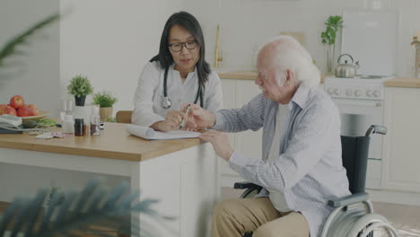 doctor discussing medication with elderly patient in kitchen