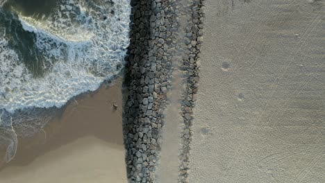 sea waves near stone wall on beach