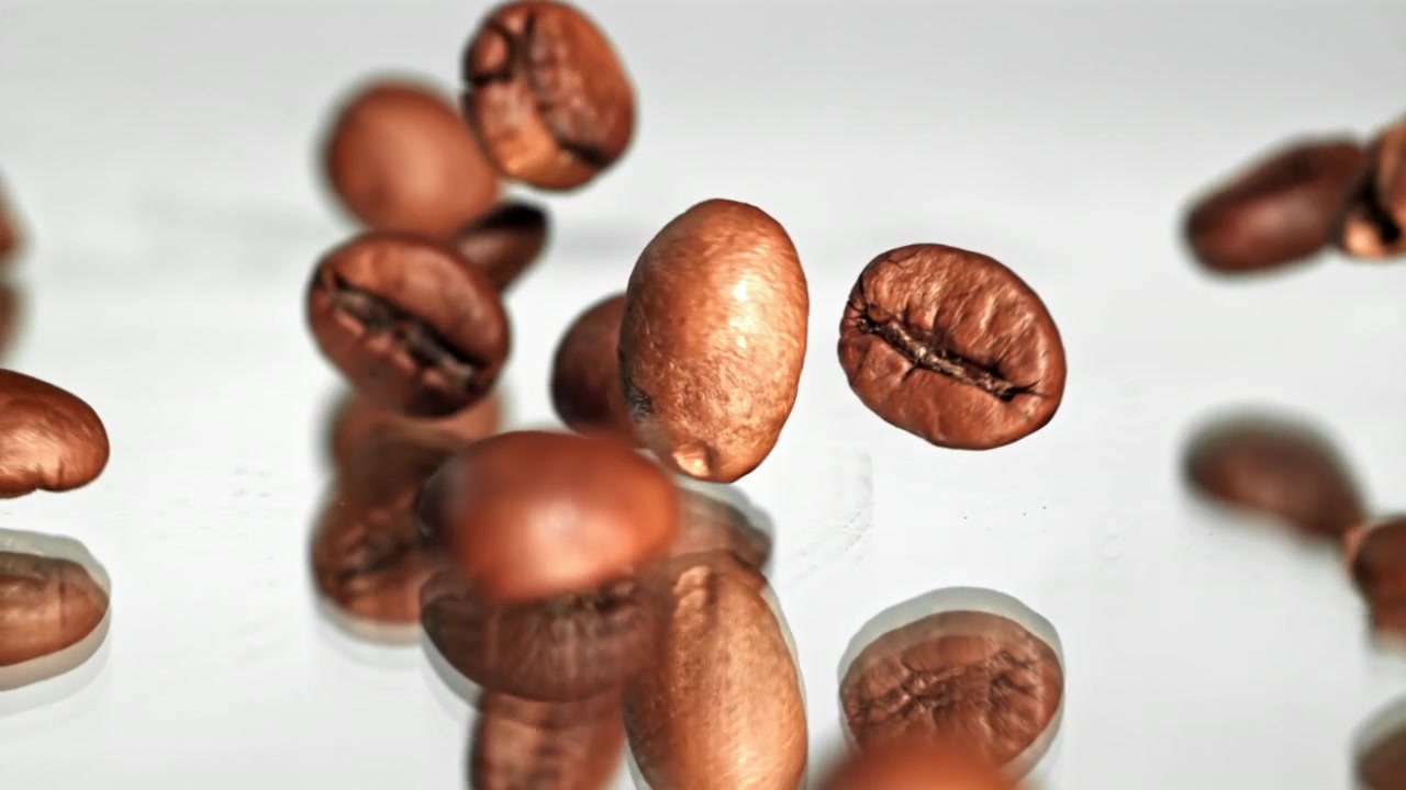 Fagioli di caffè arrostiti che cadono al rallentatore