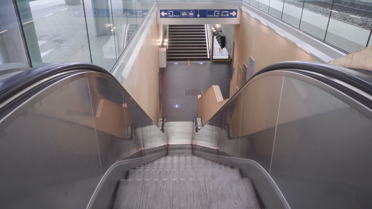 escalera mecánica en movimiento en la estación de tren vacía durante el cierre de covid-19, lovaina, bélgica