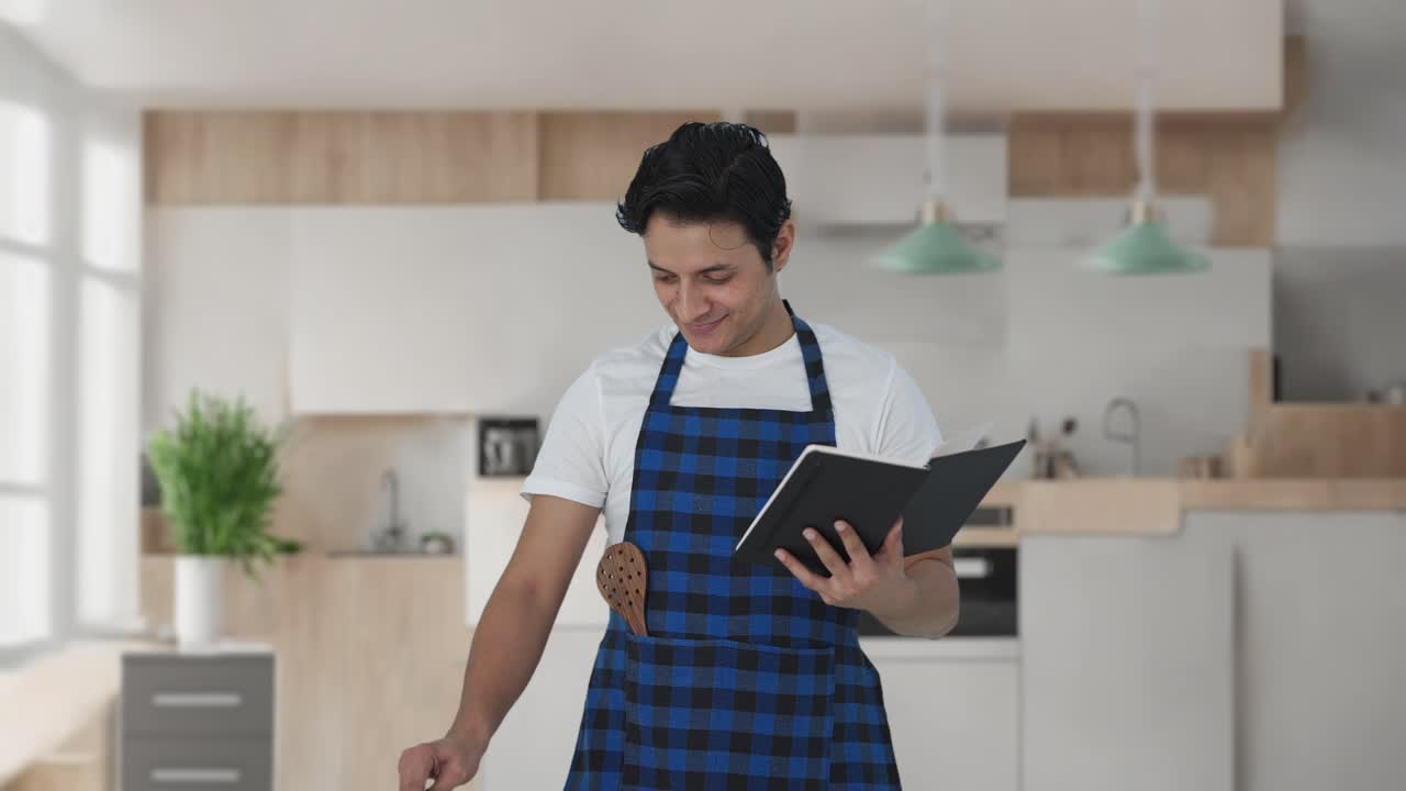 cocinero indio haciendo comida a partir de libros de recetas